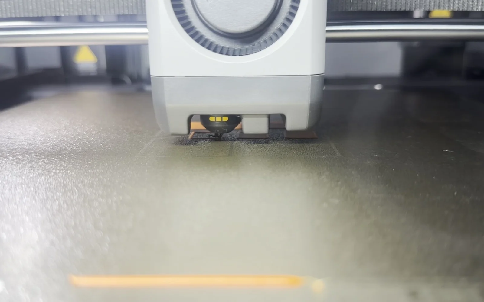 A close-up of the 3D printer working on a part